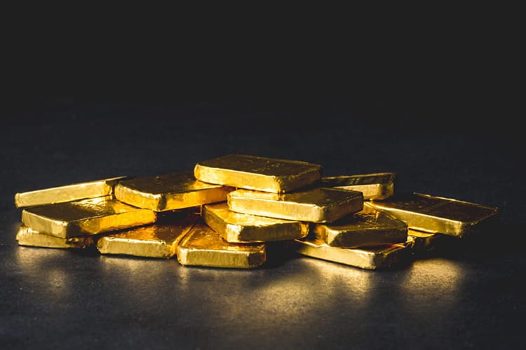 Gold gains due to a weaker dollar as traders wait for new US economic data